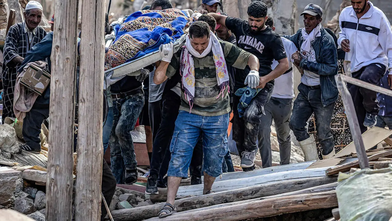 AFP/FADEL SENNA - La gente lleva los restos de una víctima del mortal terremoto de magnitud 6,8 del 8 de septiembre, en la aldea de Imi NTala, cerca de Amizmiz, en el centro de Marruecos, el 10 de septiembre de 2023