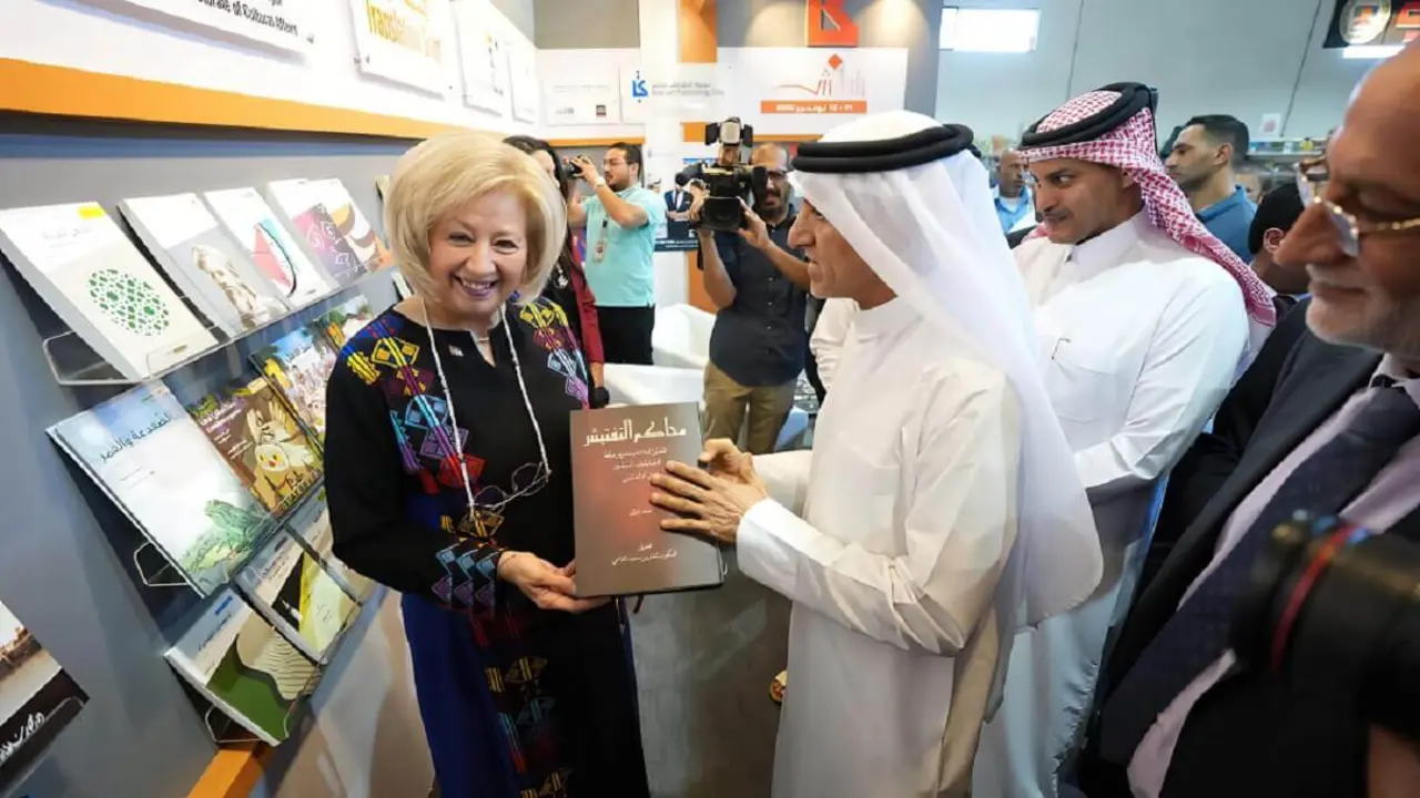La ministra de Cultura jordana al recibir un ejemplar del libro "Los manuscritos de la Inquisición" durante su visita al pabellón de la SBA