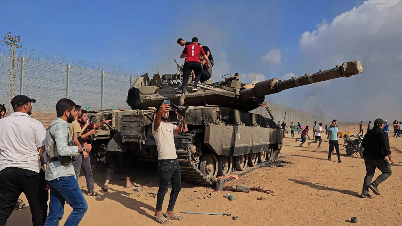 AFP/SAID KHATIB - Los palestinos toman el control de un tanque israelí después de cruzar la valla fronteriza con Israel desde Khan Yunis en el sur de la Franja de Gaza el 7 de octubre de 2023