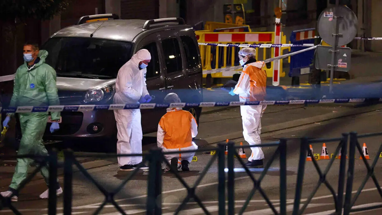 AFP/KENZO TRIBOUILLARD  - Agentes de policía belgas del servicio forense buscan pruebas en una calle después de que dos personas murieran durante un tiroteo en Bruselas la noche del 16 de octubre de 2023