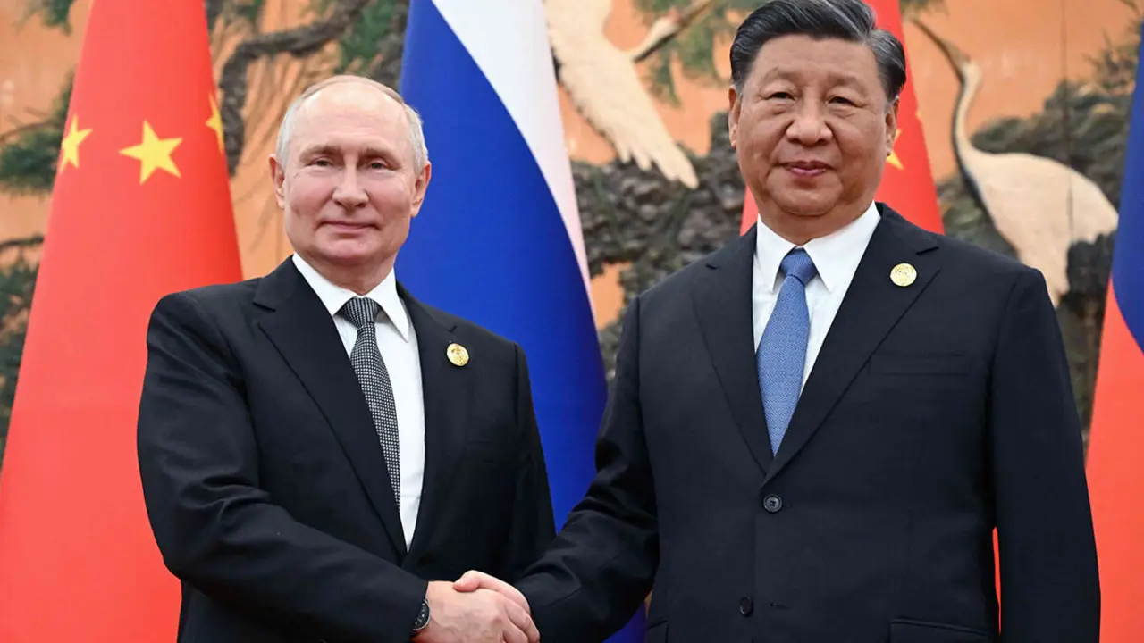 El presidente ruso Vladimir Putin y al presidente chino Xi Jinping dándose la mano durante una reunión en Pekín el 18 de octubre de 2023 -AFP/SERGEI GUNEYEV