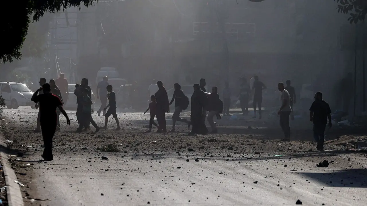 AFP/MOHAMMED ABED  - Palestinos evacuan un vecindario en la ciudad de Gaza durante los ataques aéreos israelíes el 11 de octubre de 2023
