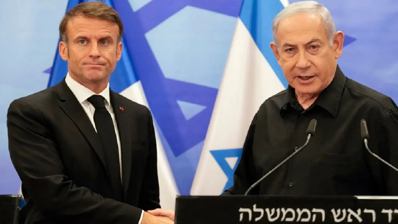 PHOTO/POOL/AFP/CHRISTOPHE ENA - TOPSHOT - El primer ministro israelí, Benjamin Netanyahu (Derecha), estrecha la mano del presidente francés, Emmanuel Macron (Izquierda), tras su rueda de prensa conjunta en Jerusalén el 24 de octubre de 2023
