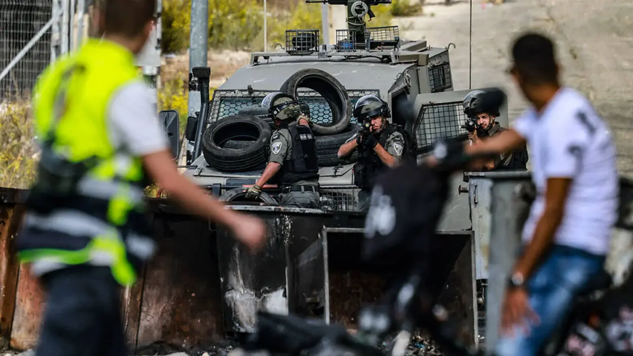 AFP/JAAFAR ASHITIYEH - Un hombre palestino conduce una motocicleta mientras se enfrenta a las tropas israelíes durante los enfrentamientos con ellas en la entrada norte de la ciudad de Ramallah, en Cisjordania, cerca del asentamiento israelí de Beit El, el 20 de octubre de 2023, mientras continúan las batallas entre Israel y el grupo palestino Hamás