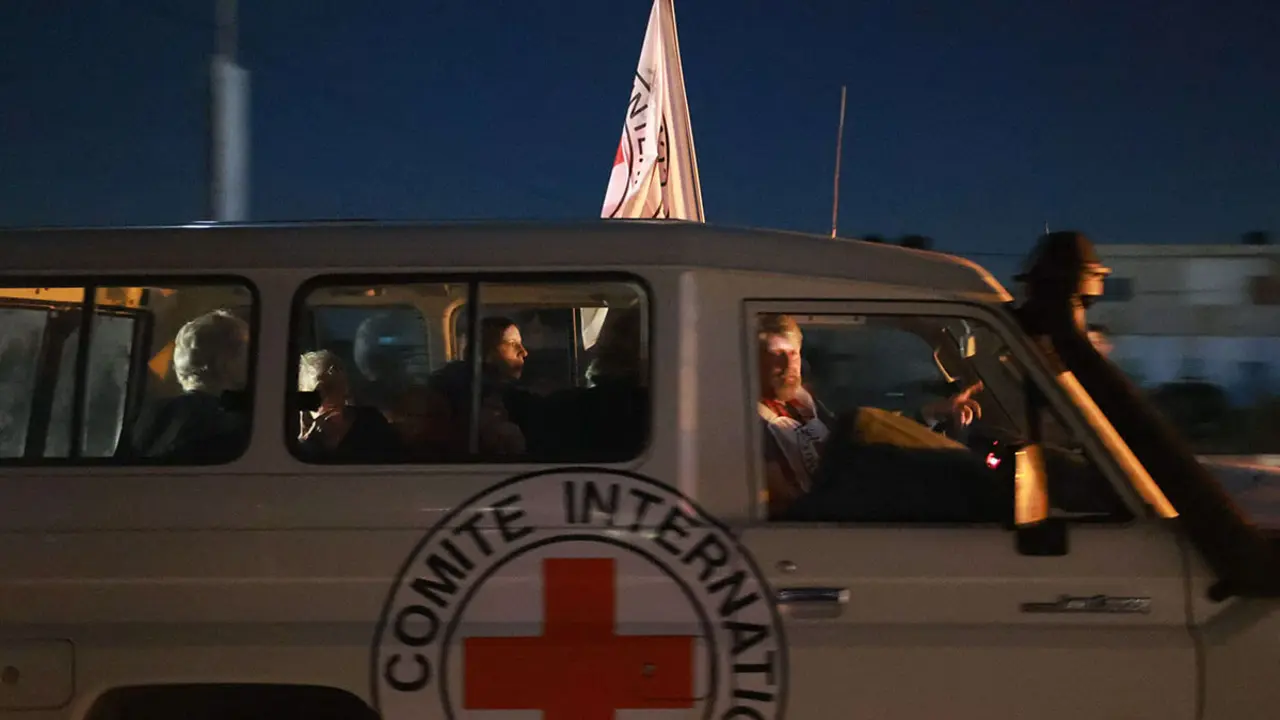 AFP/ MOHAMMED ABED - Un vehículo de la Cruz Roja Internacional con rehenes liberados por Hamás cruza el paso fronterizo de Rafah en la Franja de Gaza hacia Egipto