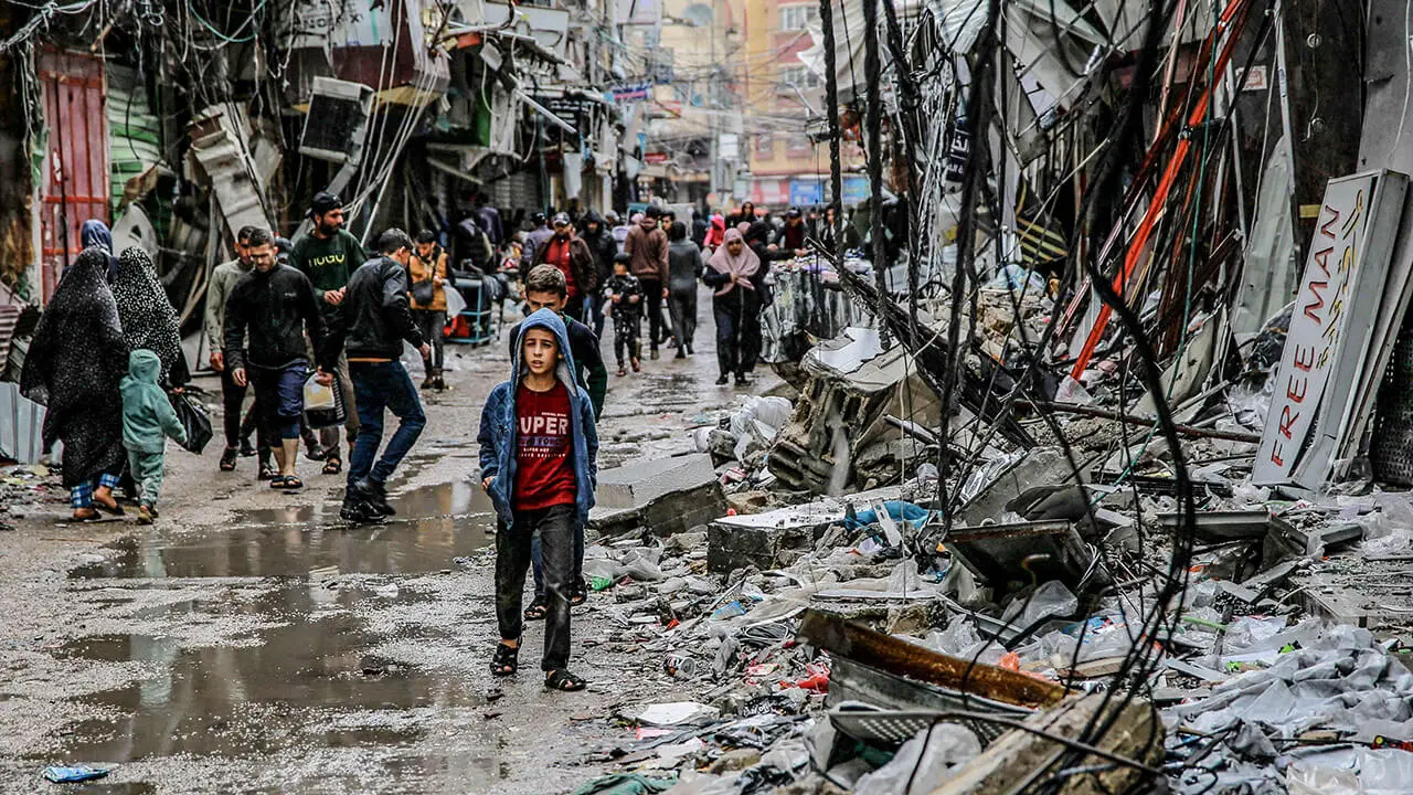 Palestinos caminan entre los escombros de los edificios afectados por los ataques israelíes, cerca del mercado de Al-Zawiya en la ciudad de Gaza el 27 de noviembre de 2023, en el cuarto día de una tregua en los combates entre Israel y Hamás
AFP/OMAR EL-QATTAA