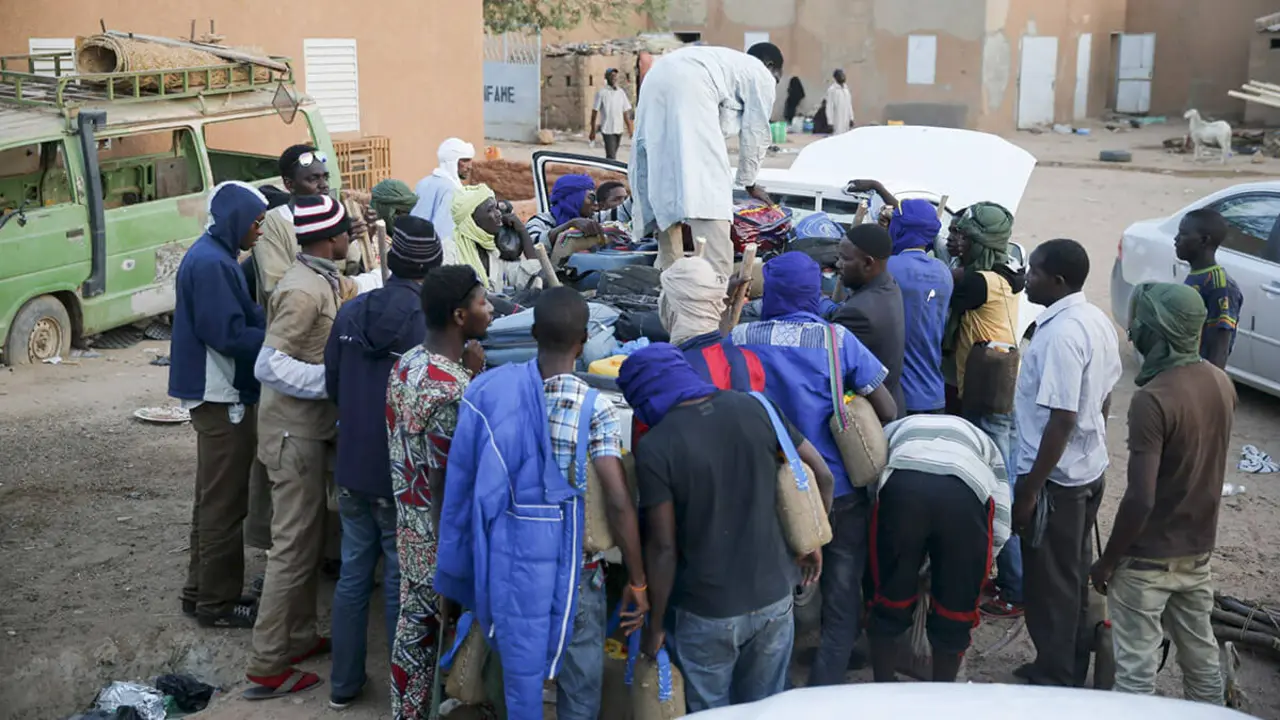 Migrantes observan cómo un hombre arregla sus pertenencias en la parte trasera de un camión en un centro de tránsito de inmigración local en la ciudad desértica de Agadez, Níger - REUTERS/AKINTUNDE AKINLEYE