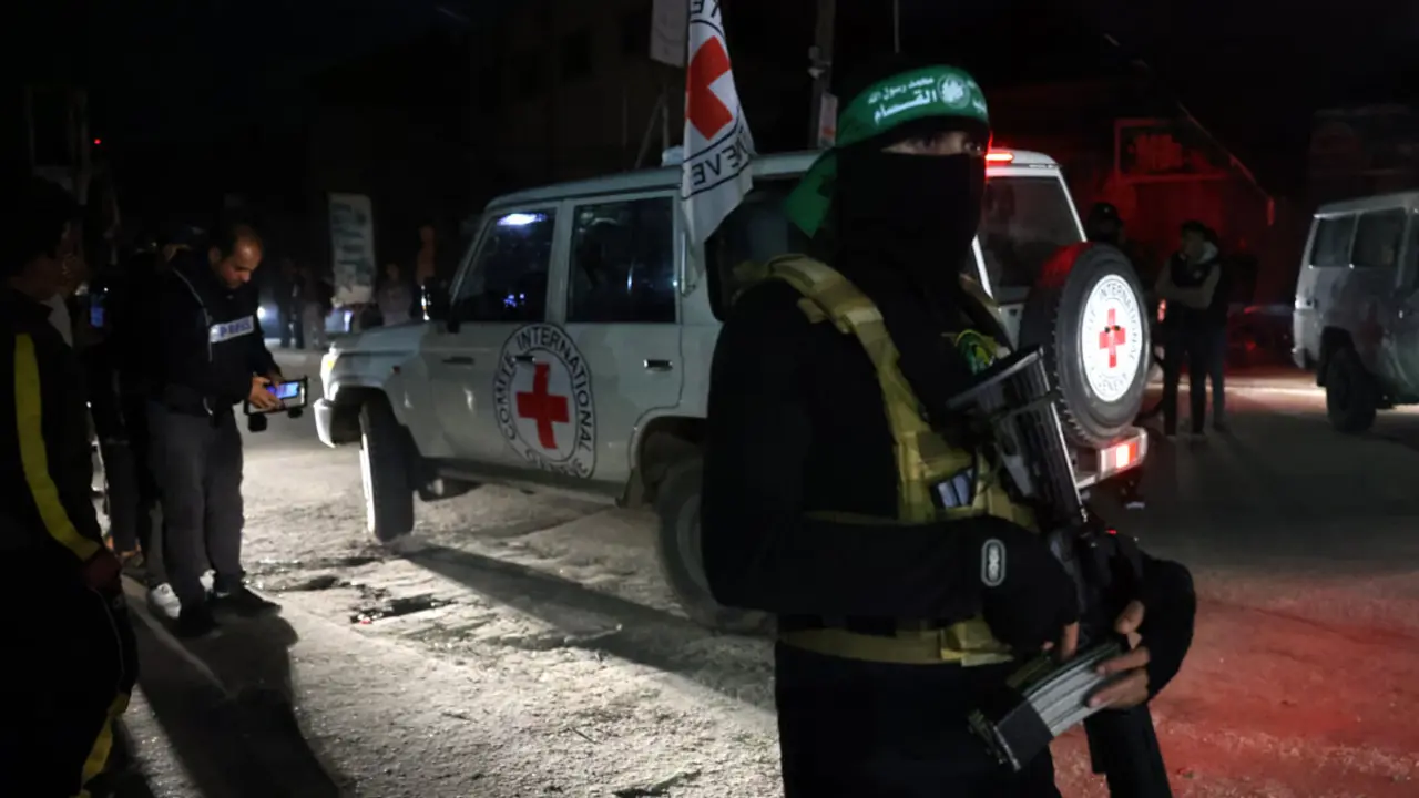 Un combatiente de Hamás hace guardia mientras un vehículo de la Cruz Roja transporta a rehenes recién liberados en Rafah, en el sur de la Franja de Gaza, el 28 de noviembre de 2023 - AFP