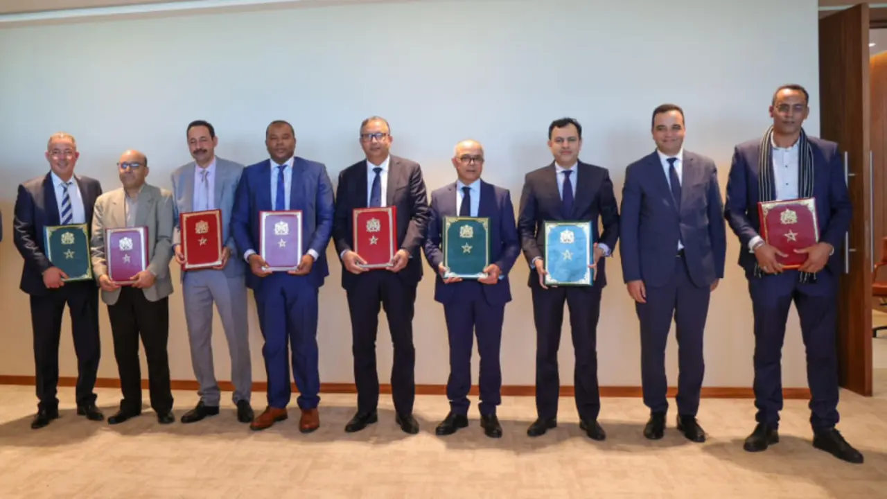 El ministro de Educación de Marruecos, Chakib Benmoussa (en el centro), posa con los representantes de los sindicatos de educación tras la firma del acuerdo, el 26 de diciembre de 2023 (https://cg.gov.ma/)