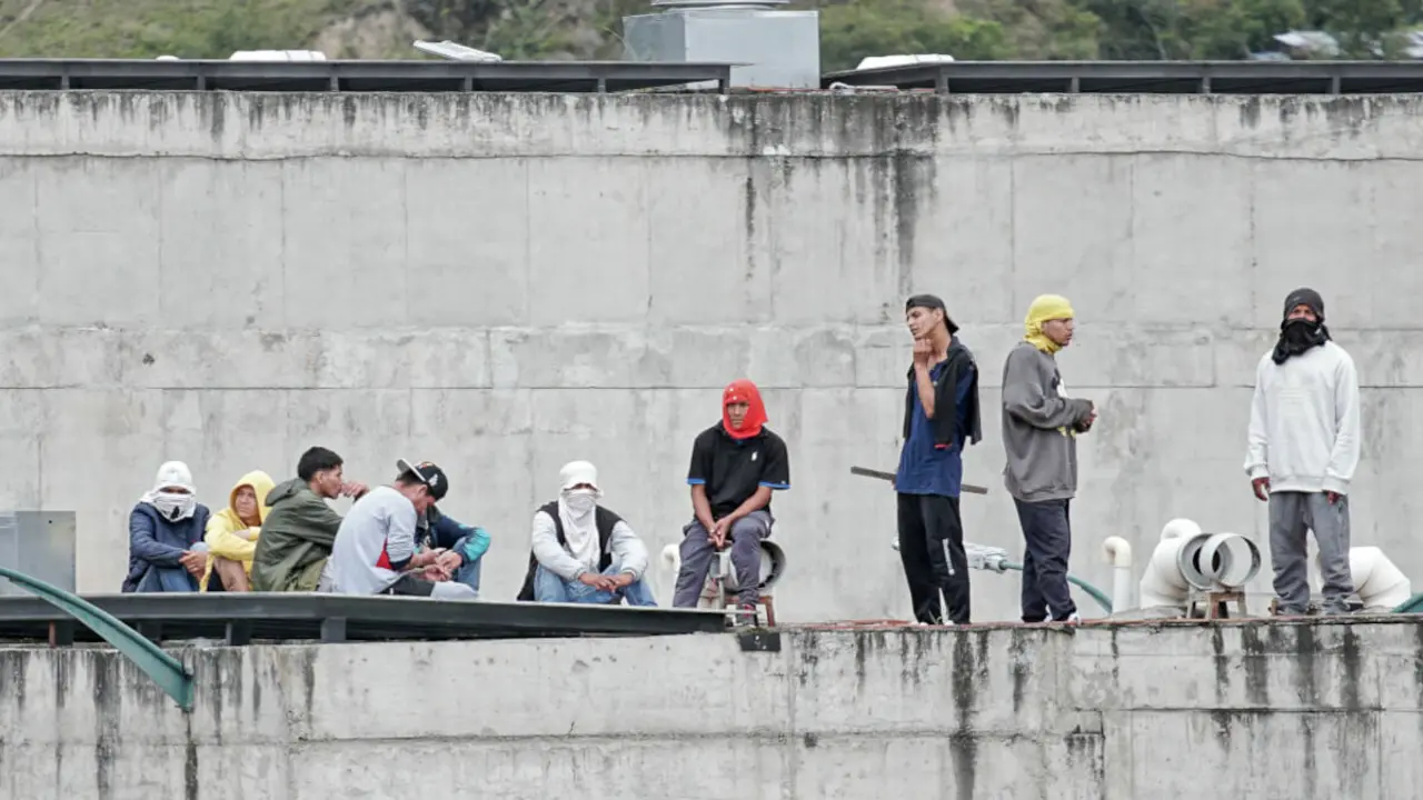 Los reclusos permanecen en el techo de la prisión de Turi, donde los guardias de la prisión han sido mantenidos como rehenes, en Cuenca, Ecuador, el 8 de enero de 2024. El líder de la principal banda criminal de Ecuador, Adolfo Macías, alias "Fito", se habría fugado el 7 de enero "horas antes" de un operativo en la cárcel donde cumplía condena, informó el lunes el secretario general de Comunicación, Roberto Izurieta (Foto de FERNANDO MACHADO / AFP)