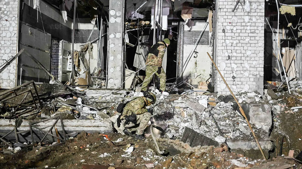 Expertos en explosivos militares ucranianos examinan el sitio de un hotel destruido tras un ataque con misiles en Kharkiv, el 11 de enero de 2024, en medio de la invasión rusa de Ucrania - AFP/SERGEY BOBOK