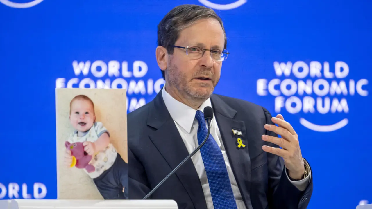 El presidente israelí, Isaac Herzog, muestra al bebé Kfir Bibas, retenido por Hamás, durante el Foro de Davos - Fabrice COFFRINI / AFP