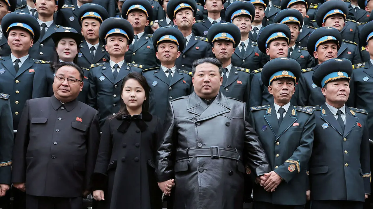 El líder de Corea del Norte, Kim Jong Un, y su hija posando con científicos que contribuyeron al lanzamiento de un satélite de reconocimiento, en la Dirección Nacional de Tecnología Aeroespacial en Pyongyang - AFP/ KCNA VIA KNS