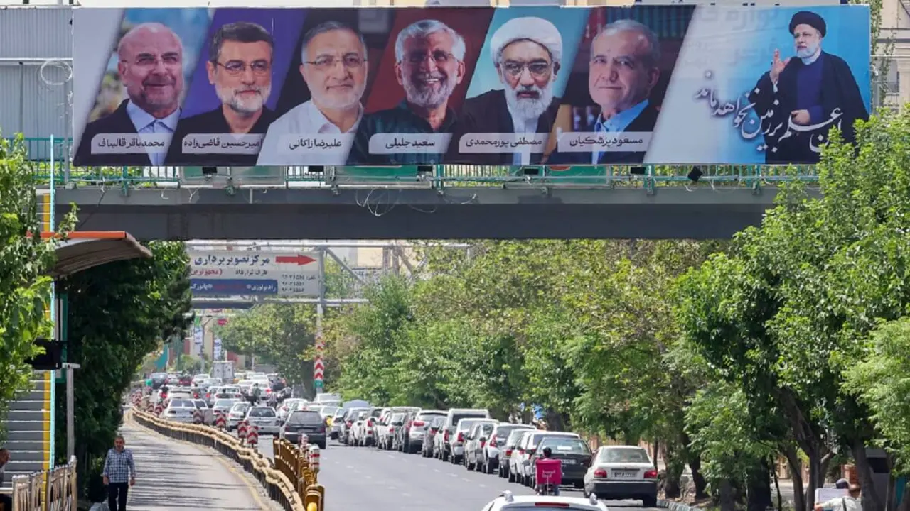 Vehículos pasan junto a una valla publicitaria con los rostros de los seis candidatos presidenciales (de izquierda a derecha) Mohammad Bagher Ghalibaf, Amirhossein Ghazizadeh-Hashemi Alireza Zakani, Saeed Jalili, Mostafa Pourmohammadi y Masoud Pezeshkianin en la capital iraní, Teherán, el 29 de junio de 2024 – PHOTO/ATTA KENARE/AFP