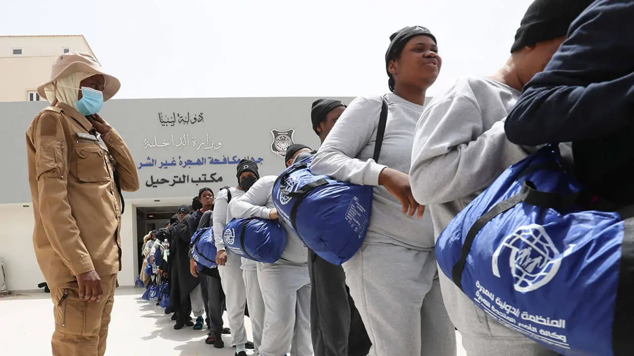 Migrantes irregulares nigerianos hacen cola para subir a los autobuses de la oficina antimigración con destino al aeropuerto internacional de Mitiga, en Trípoli, el 25 de junio de 2024 - AFP/MAHMUD TURKIA