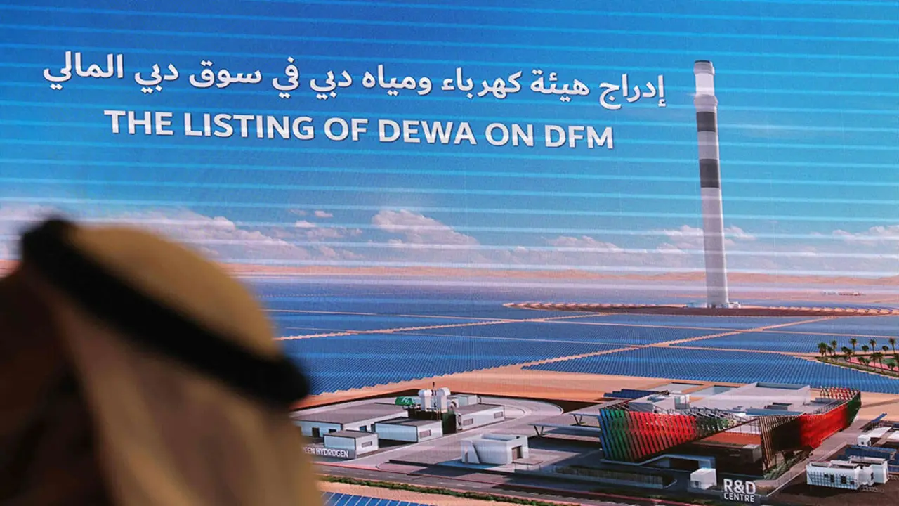 <p>Una pantalla electrónica anuncia la cotización de las acciones de la Autoridad de Electricidad y Agua de Dubái (DEWA) en la bolsa de valores del Mercado Financiero de Dubái - AFP/GIUSEPPE CACACE</p>
