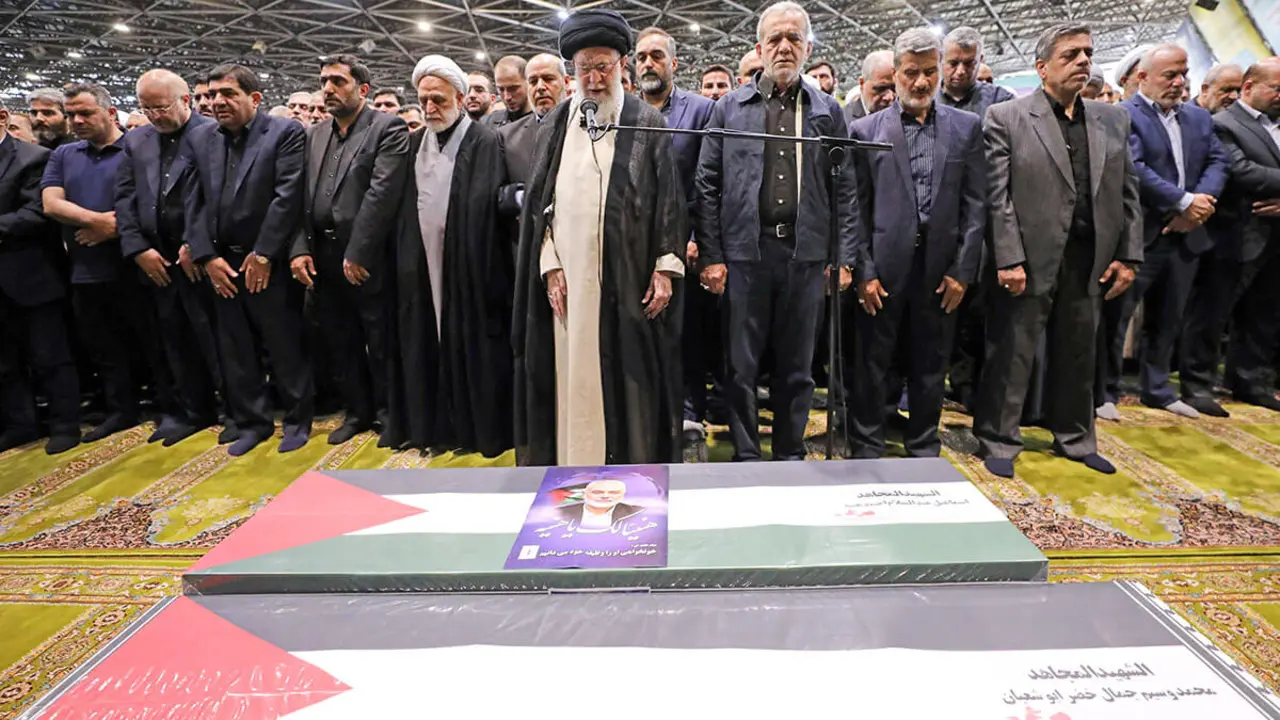 El ayatolá Ali Jamenei, dirigiendo la oración, junto al presidente iraní Masoud Pezeshkian frente al ataúd del líder de Hamás, Ismail Haniyeh, y su guardaespaldas - AFP / HO / PRESIDENCIA DE IRAN&nbsp;
