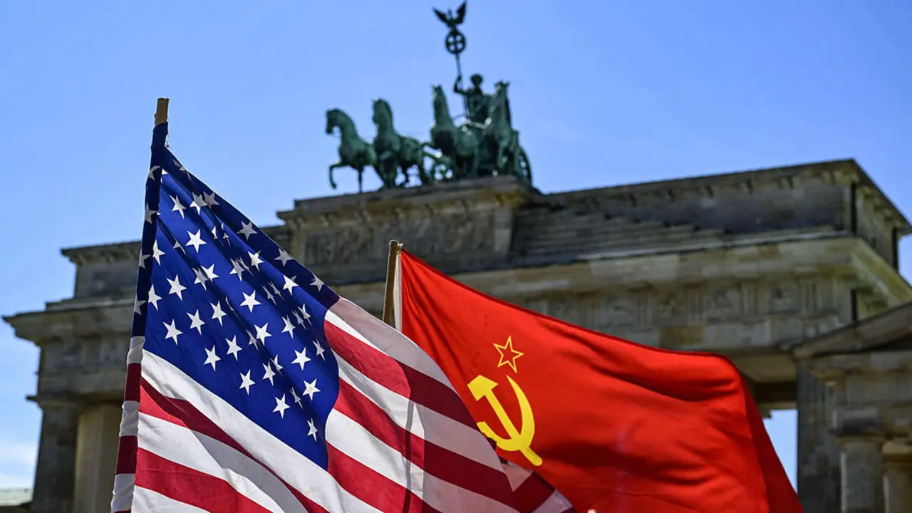 La bandera estadounidense y la exsoviética ondean frente a la Puerta de Brandeburgo - AFP/JOHN MACDOUGALL