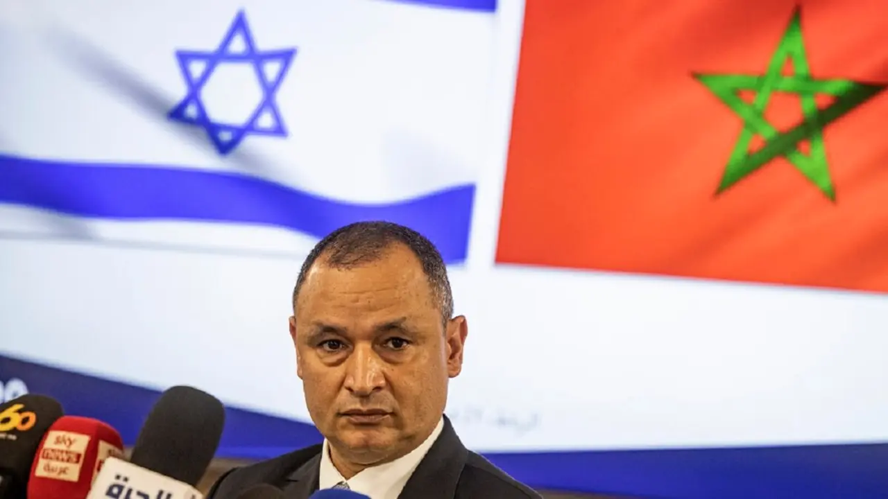 El ministro marroquí de Industria y Comercio, Ryad Mezzour, se dirige a los medios de comunicación bajo las banderas de su país y de Israel (izq.) tras su reunión con la ministra israelí de Economía, Orna Barbivai, en Rabat el 21 de febrero de 2022 – PHOTO/FADEL SENNA/AFP