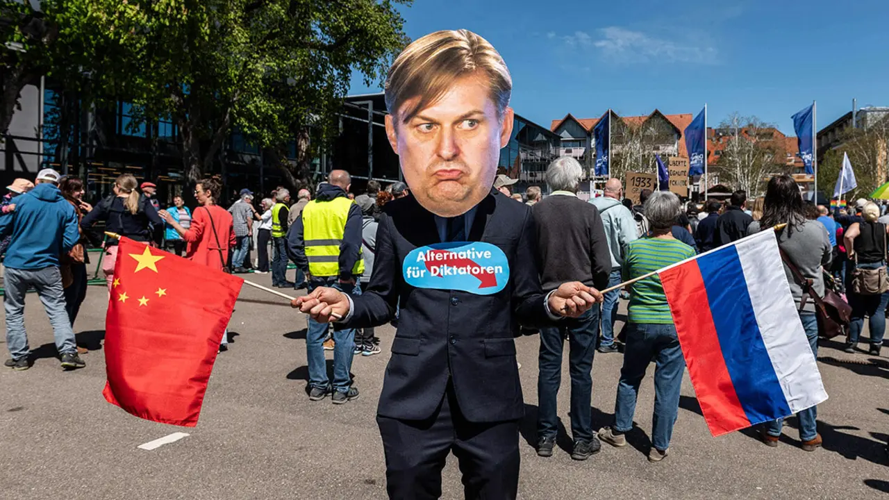 Un manifestante con una máscara del político alemán de extrema derecha Maximilian Krah del partido Alternativa para Alemania (AfD) sostiene una bandera china y otra rusa y tiene un cartel fijado en el pecho que dice Alternativa para dictadores -&nbsp;AFP/ &nbsp;SILAS STEIN&nbsp;