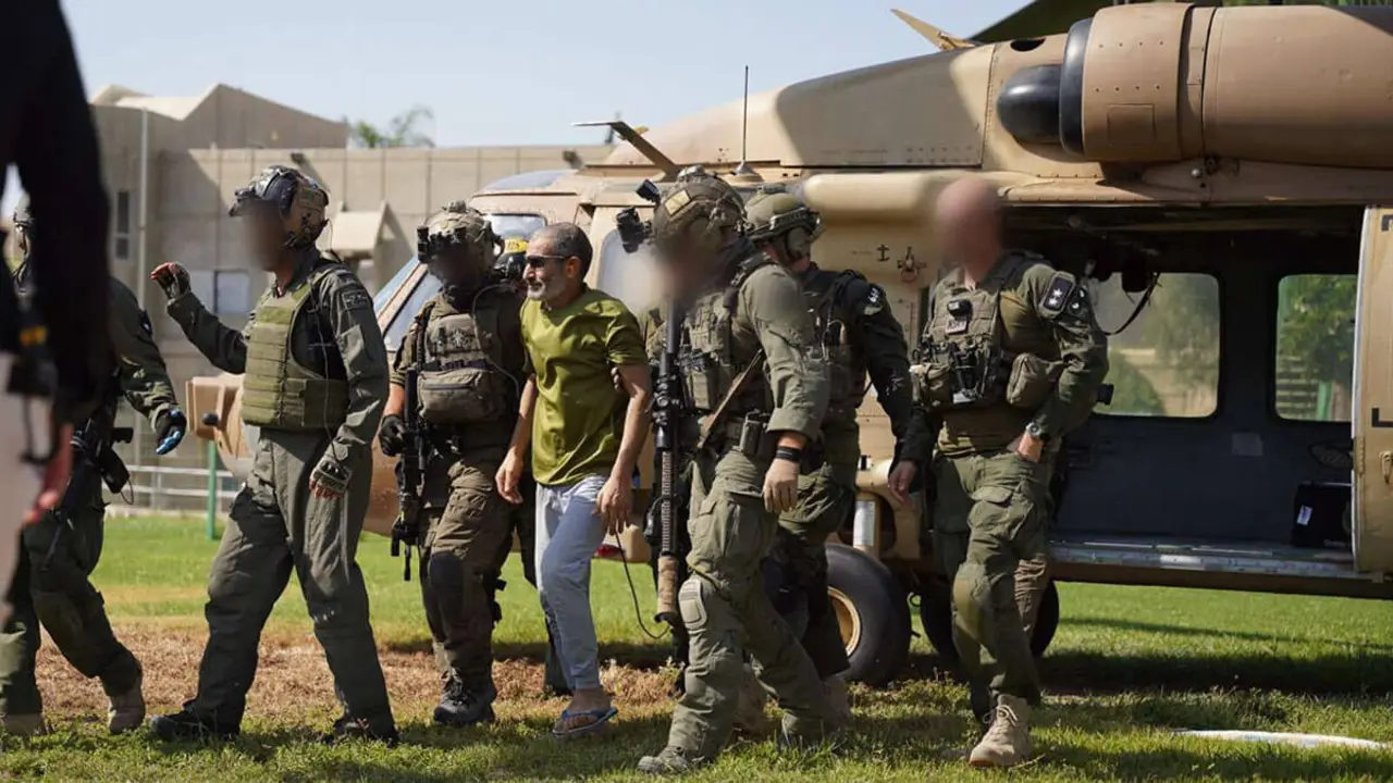 Esta fotografía difundida por el ejército israelí el 27 de agosto de 2024 muestra al rehén israelí liberado Kaid Alkadi acompañado de soldados mientras desembarca de un helicóptero militar en el Centro Médico Soroka en Beersheba - AFP / Difundida / Ejército israelí