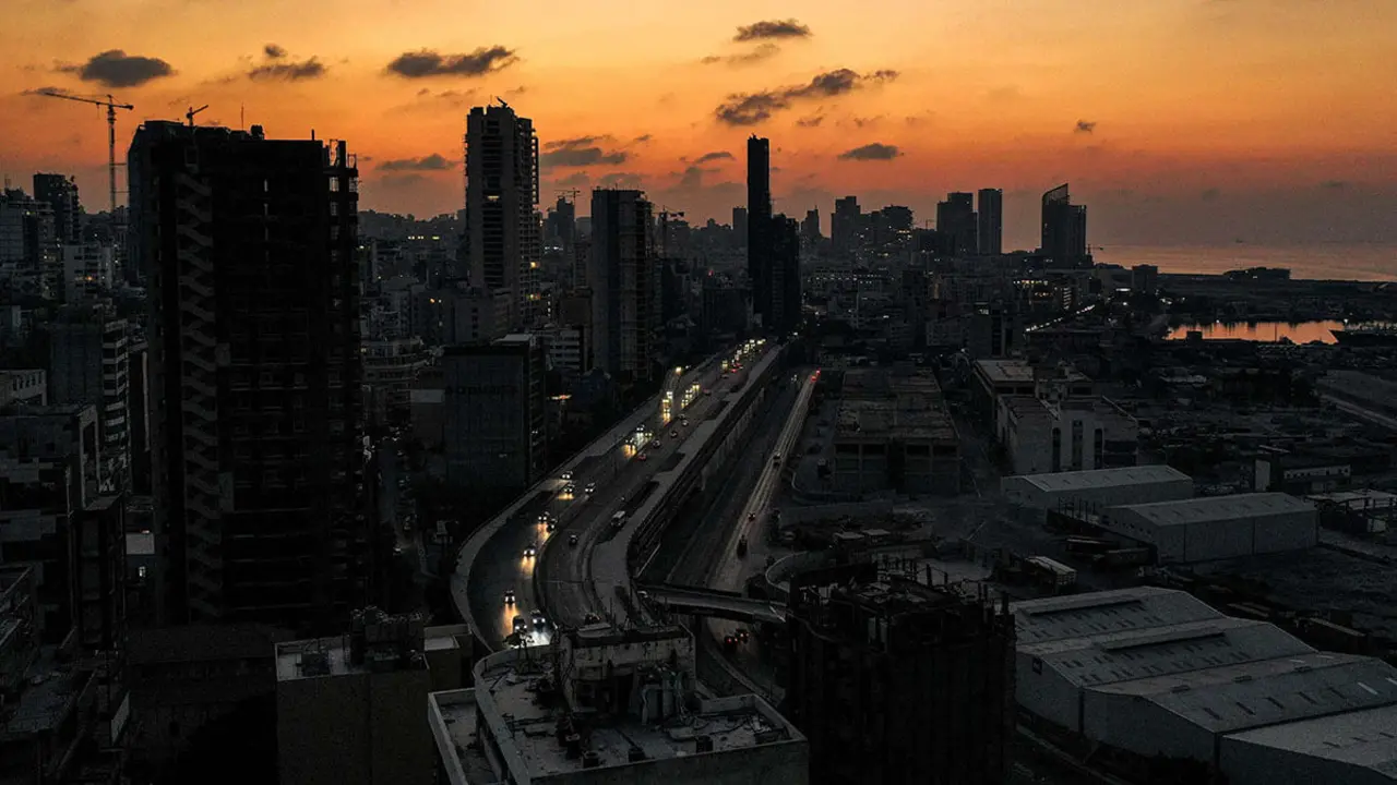 <p>Vista aérea al anochecer de automóviles que pasan frente a edificios sin iluminación a lo largo de la autopista Charles Helou junto al devastado puerto de la capital libanesa, Beirut, en la oscuridad durante un corte de energía - PHOTO/ AFP</p>
