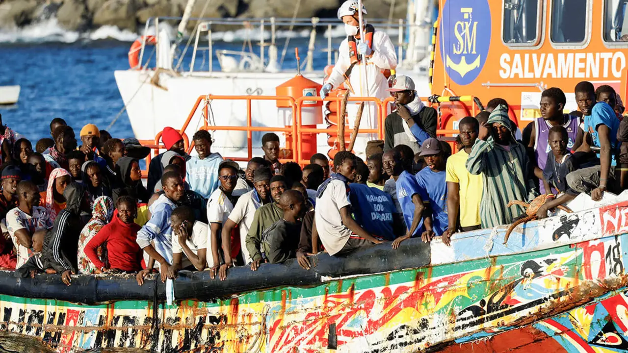 <p>Un grupo de migrantes en una embarcación de madera son remolcados por un buque de la guardia costera española hasta el puerto de Arguineguín, en la isla de Gran Canaria, España, el 21 de octubre de 2023 - REUTERS/BORJA SUÁREZ&nbsp;</p>
