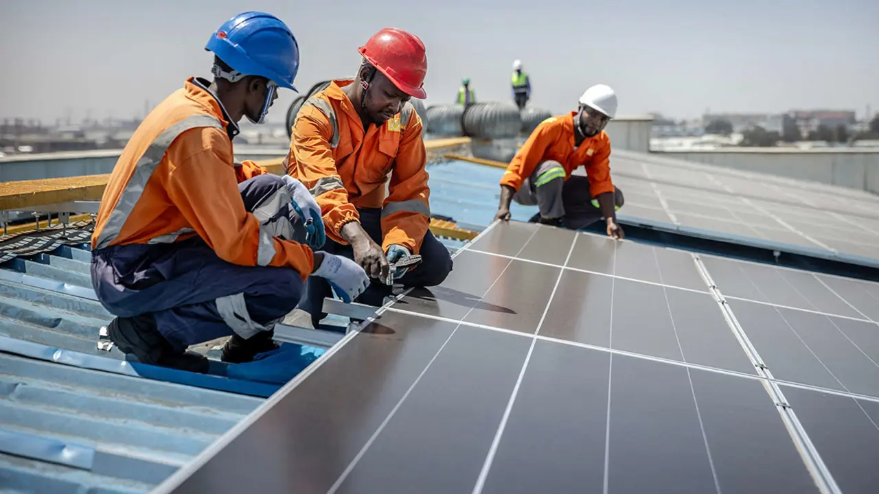 <p>Técnicos de CP Solar trabajan en la instalación de paneles solares en una fábrica que funciona parcialmente con energía solar en la zona industrial de Nairobi - AFP/ LUIS TATO&nbsp;</p>
