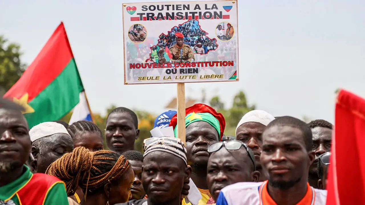 Una persona sostiene un cartel con la imagen del capitán Ibrahim Traore mientras asiste a una manifestación de partidarios de la junta de Burkina Faso para conmemorar el primer aniversario del golpe de Estado que llevó a Traore al poder en Uagadugú, Burkina Faso, el 29 de septiembre de 2023 - REUTERS/YEMPABOU OUOBA
