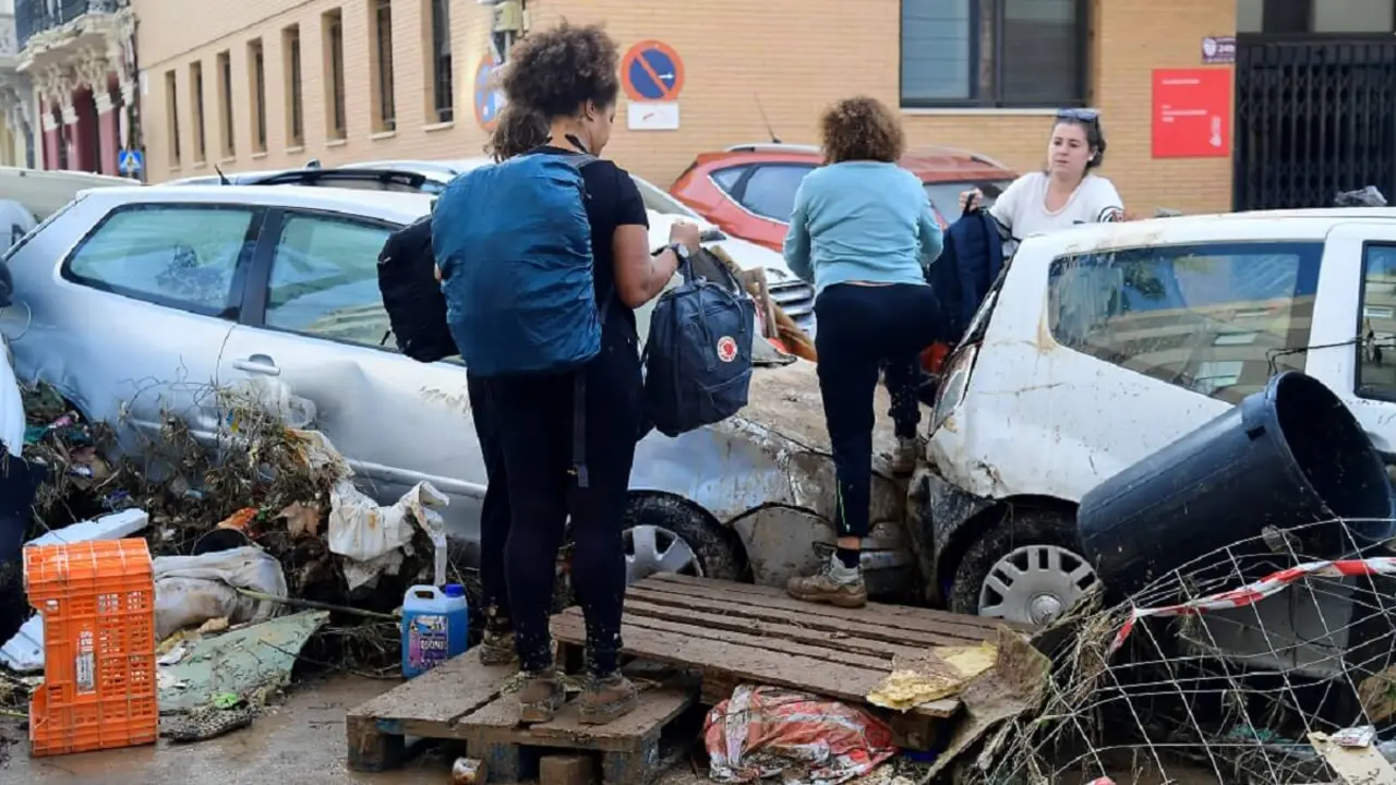 <p>Residentes pasan junto a coches apilados tras las inundaciones mortales en Sedavi, al sur de Valencia, este de España, el 30 de octubre de 2024 - PHOTO/AFP/José&nbsp;Jordán</p>
