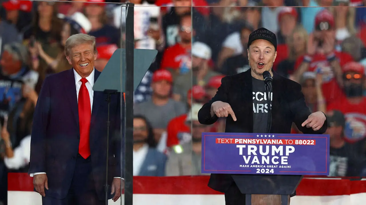Elon Musk, director ejecutivo de Tesla y propietario de X, habla mientras el candidato presidencial republicano y expresidente estadounidense Donald Trump reacciona durante un mitin en el lugar del intento de asesinato de julio contra Trump, en Butler, Pensilvania, EE. UU., el 5 de octubre de 2024 - REUTERS/CARLOS BERRIA