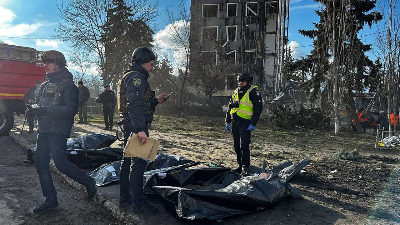 Oficiales de policía se encuentran cerca de bolsas con cuerpos de personas asesinadas por ataques con misiles rusos, en medio del ataque de Rusia a Ucrania, en Izium, Ucrania, el 4 de febrero de 2025 - REUTERS/ SOFIIA GATILOVA