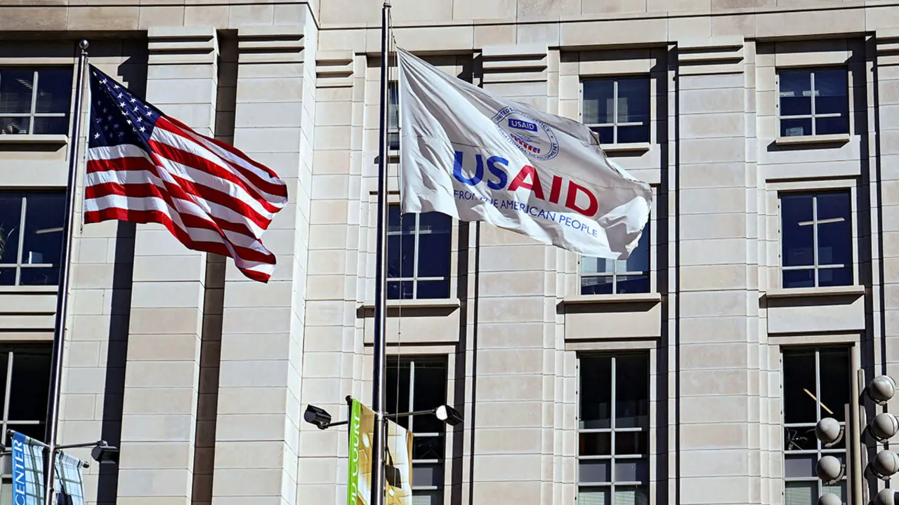 Una bandera estadounidense y una bandera de USAID ondean afuera del edificio de USAID en Washington, DC, EE. UU. - REUTERS/ANNABELLE GORDON