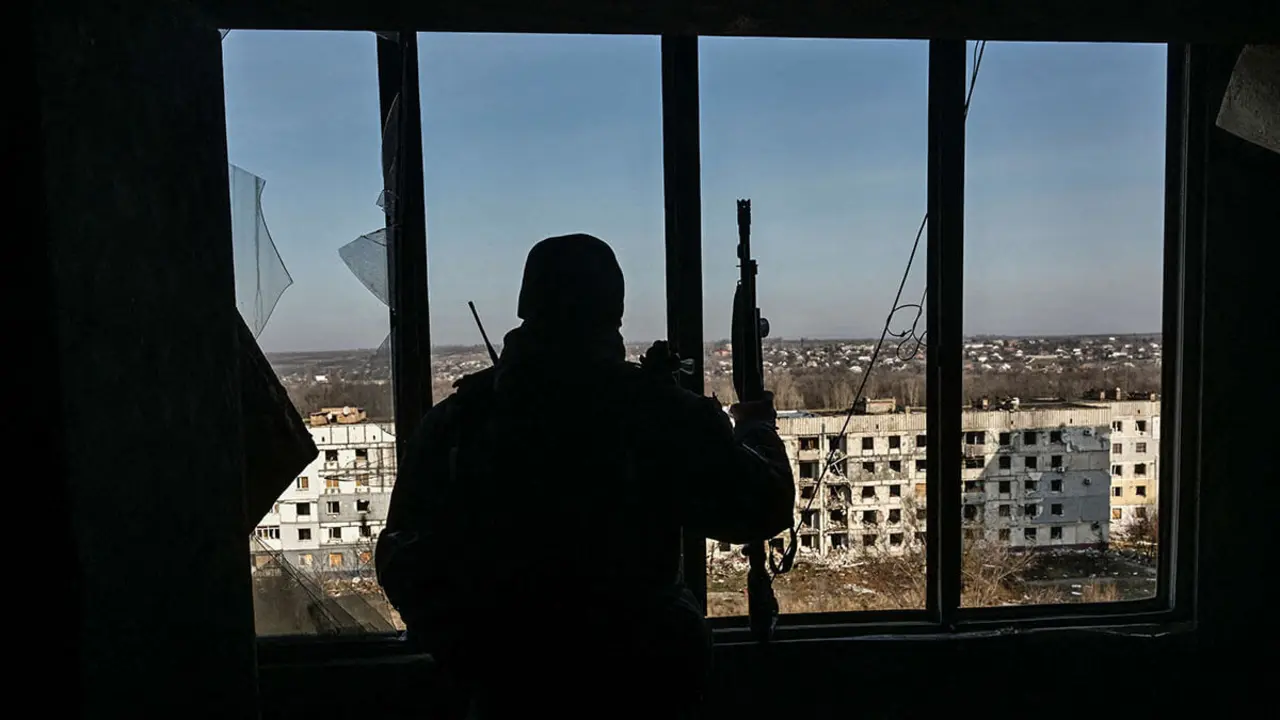 Un oficial de Policía observa un área para drones FPV enemigos desde un edificio de apartamentos dañado por ataques militares rusos en la ciudad de primera línea de Orikhiv, en medio del ataque de Rusia a Ucrania, en la región de Zaporizhia, Ucrania, el 12 de febrero de 2025 - PHOTO/REUTERS