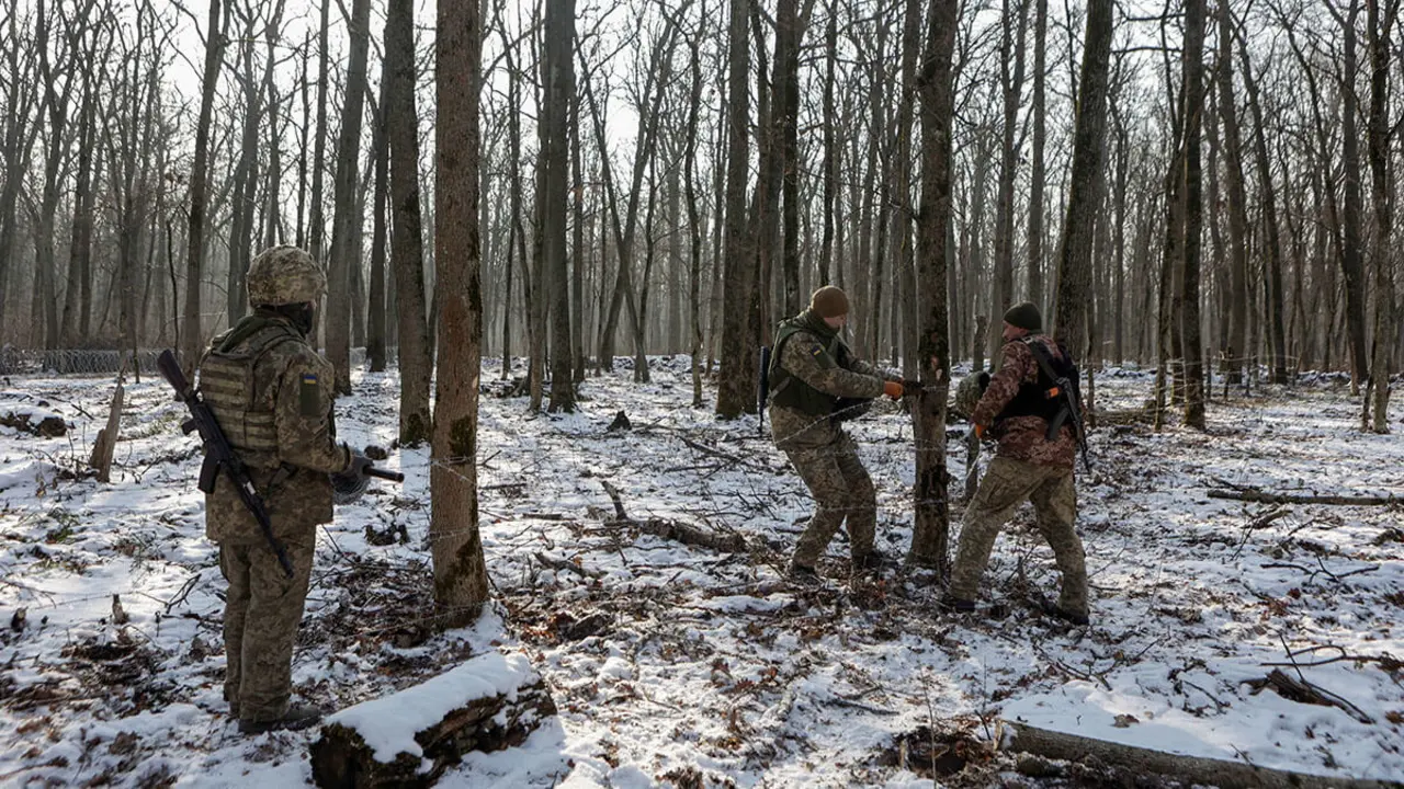 Militares ucranianos de la 211&ordf; Brigada de Puentes de Pontones de las Fuerzas Armadas de Ucrania colocan alambre de p&uacute;as como parte de un nuevo sistema de fortificaci&oacute;n, en medio del ataque de Rusia a Ucrania, en la regi&oacute;n de Kharkiv, Ucrania, el 14 de febrero de 2025 - REUTERS/ SOFIIA GATILOVA