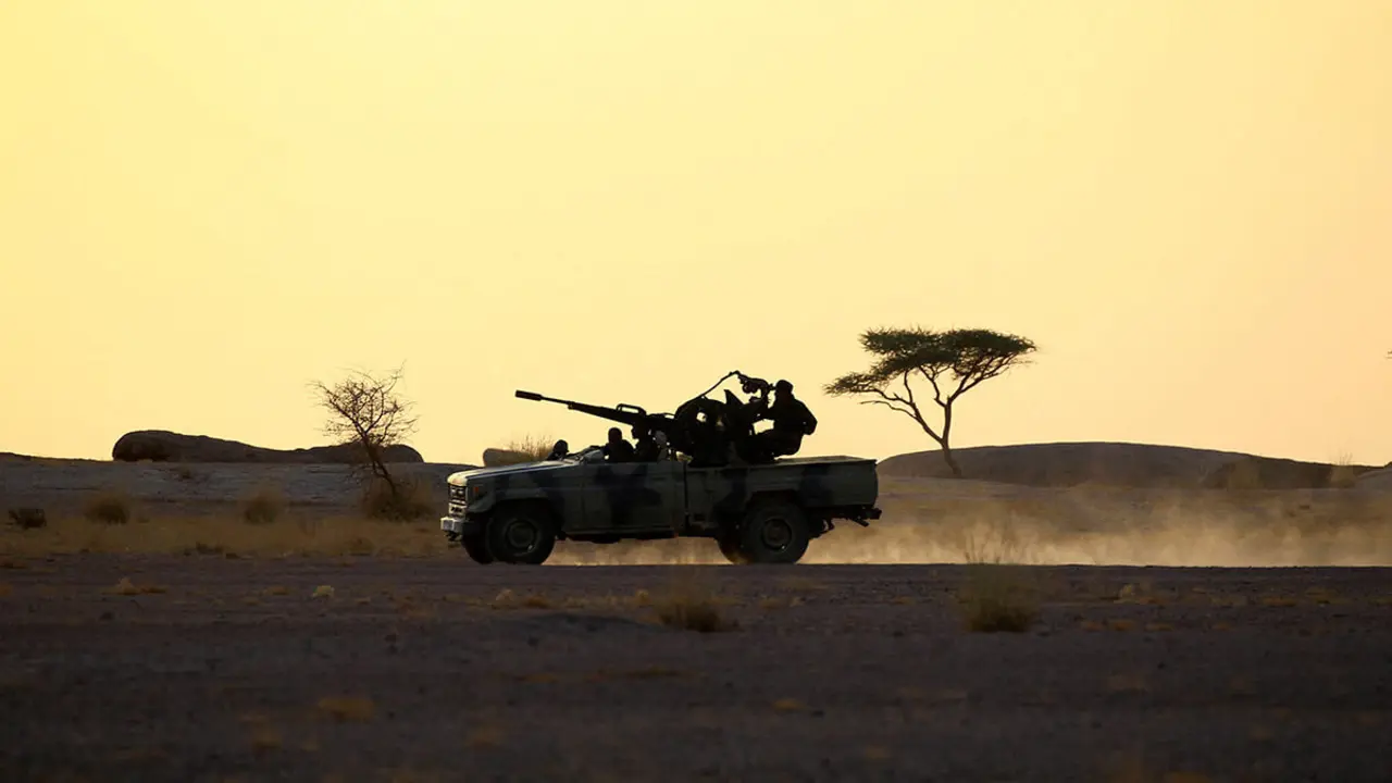 Miembros del Frente Polisario conducen una camioneta equipada con un arma antiaérea durante la puesta de sol en Bir Lahlou, Sáhara Occidental - REUTERS/ ZOHRA BENSEMRA