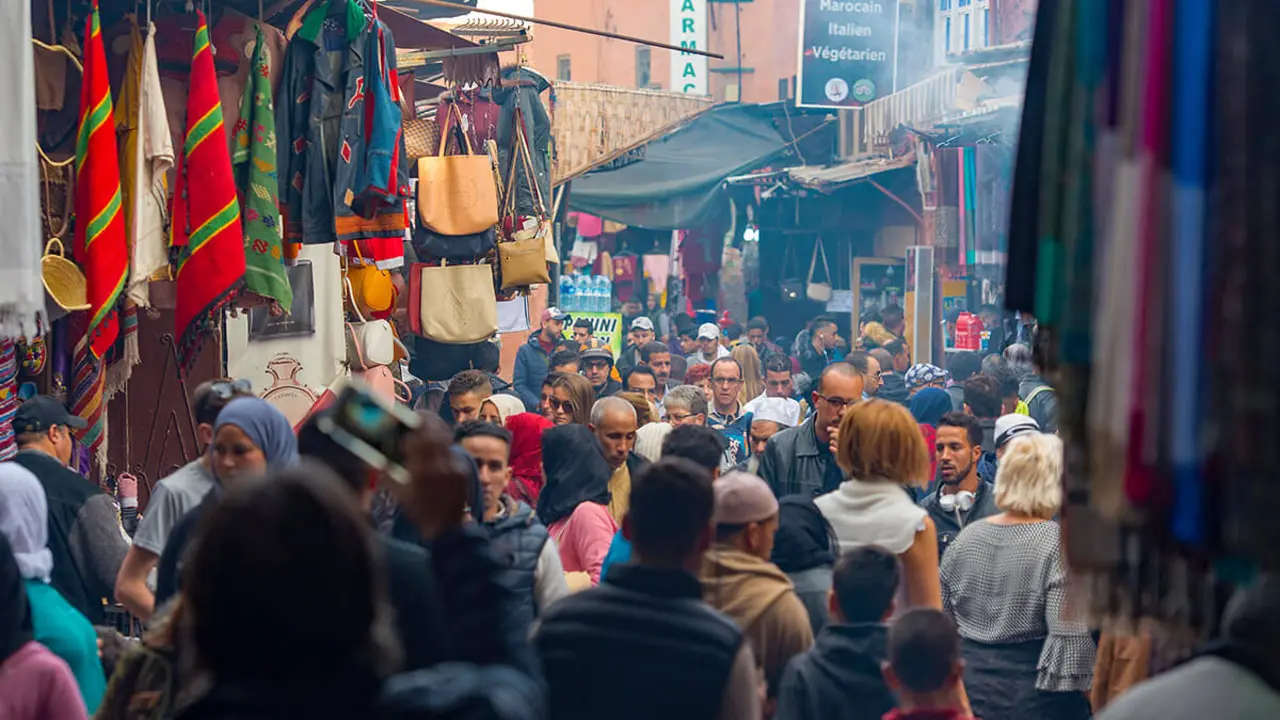 Multitud de personas en un antiguo mercado en el barrio de la medina en Marrakech - <a href="https://depositphotos.com/es/?/">Depositphotos</a>