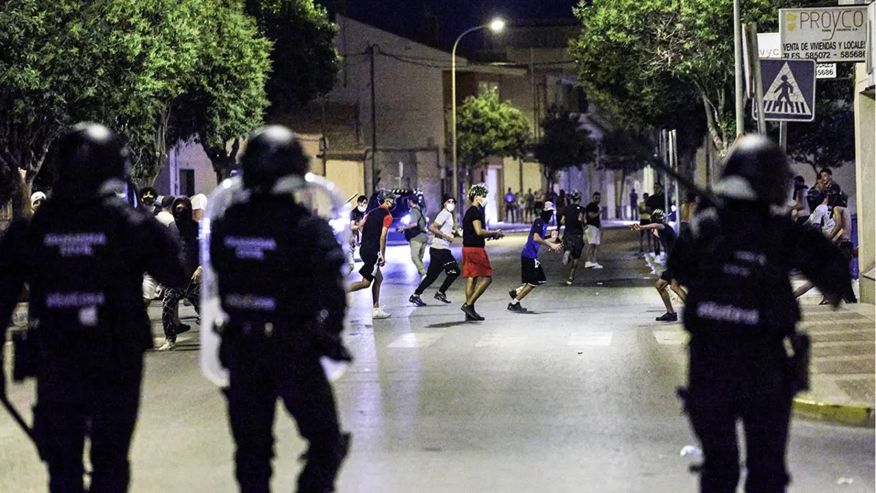 La gente corre por una calle durante enfrentamientos con la Guardia Civil, en medio de disturbios antiinmigrantes tras un ataque a un anciano por parte de asaltantes a principios de semana, en Torre Pacheco, España, el 13 de julio de 2025 - REUTERS/VIOLETA SANTOS MOURA