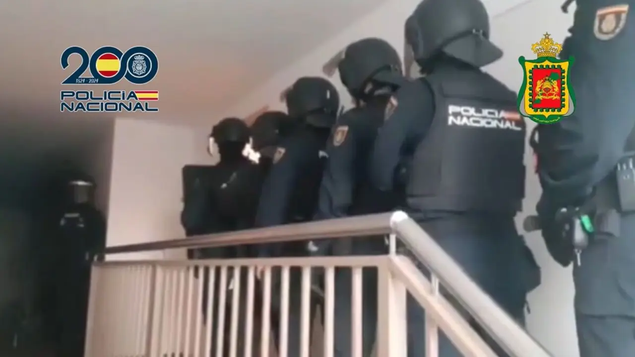 Los agentes de la Policía Nacional entrando en la vivienda de uno de los detenidos - PHOTO/Policía Nacional