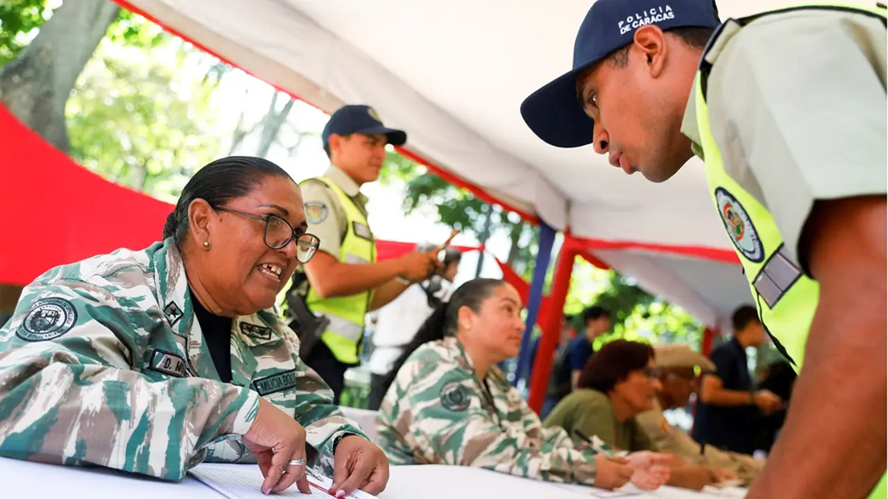 Una mujer de la Milicia Nacional Bolivariana registra a un oficial de polic&iacute;a para alistarse en la milicia luego del llamado del presidente Nicol&aacute;s Maduro a una campa&ntilde;a de reclutamiento a nivel nacional, en medio de crecientes tensiones con Estados Unidos por el despliegue de buques de guerra estadounidenses en la regi&oacute;n, en Caracas, Venezuela, el 23 de agosto de 2025 - REUTERS/ LEONARDO FERN&Aacute;NDEZ VILLORIA