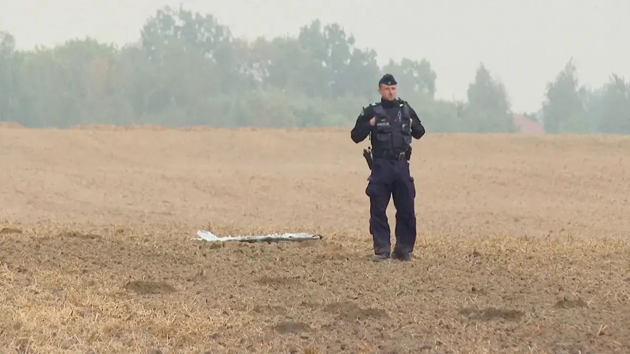 Un agente de polic&iacute;a polaco se encuentra cerca de un fragmento de un veh&iacute;culo a&eacute;reo no tripulado (UAV) despu&eacute;s de que drones rusos violaran el espacio a&eacute;reo polaco durante un ataque contra Ucrania y algunos fueran derribados por Polonia. Esto se ve en Czesniki, Voivodato de Lublin, Polonia, el 10 de septiembre de 2025 - Polsat News v&iacute;a REUTERS