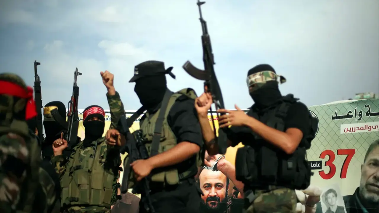 <p>Un cartel de Marwan Barghouti, el palestino de m&aacute;s alto perfil detenido en Israel, se ve mientras representantes de varias facciones armadas palestinas participan en una conferencia de prensa en apoyo a los prisioneros palestinos en huelga de hambre en c&aacute;rceles israel&iacute;es, en la ciudad de Gaza el 18 de mayo de 2017 - REUTERS/ MOHAMMED SALEM</p>
