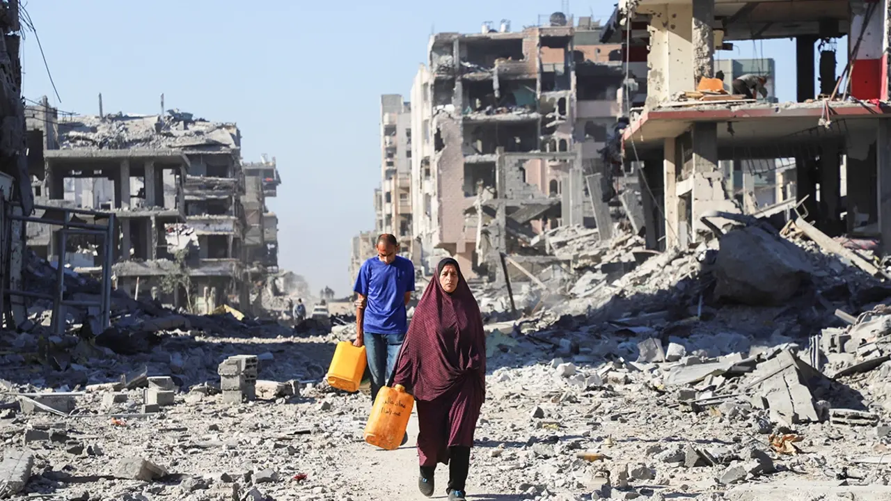 <p>Palestinos caminan entre los escombros de edificios destruidos, en medio de un alto el fuego entre Israel y Ham&aacute;s, en la ciudad de Gaza, el 15 de octubre de 2025 - REUTERS/ EBRAHIM HAJJAJA</p>
