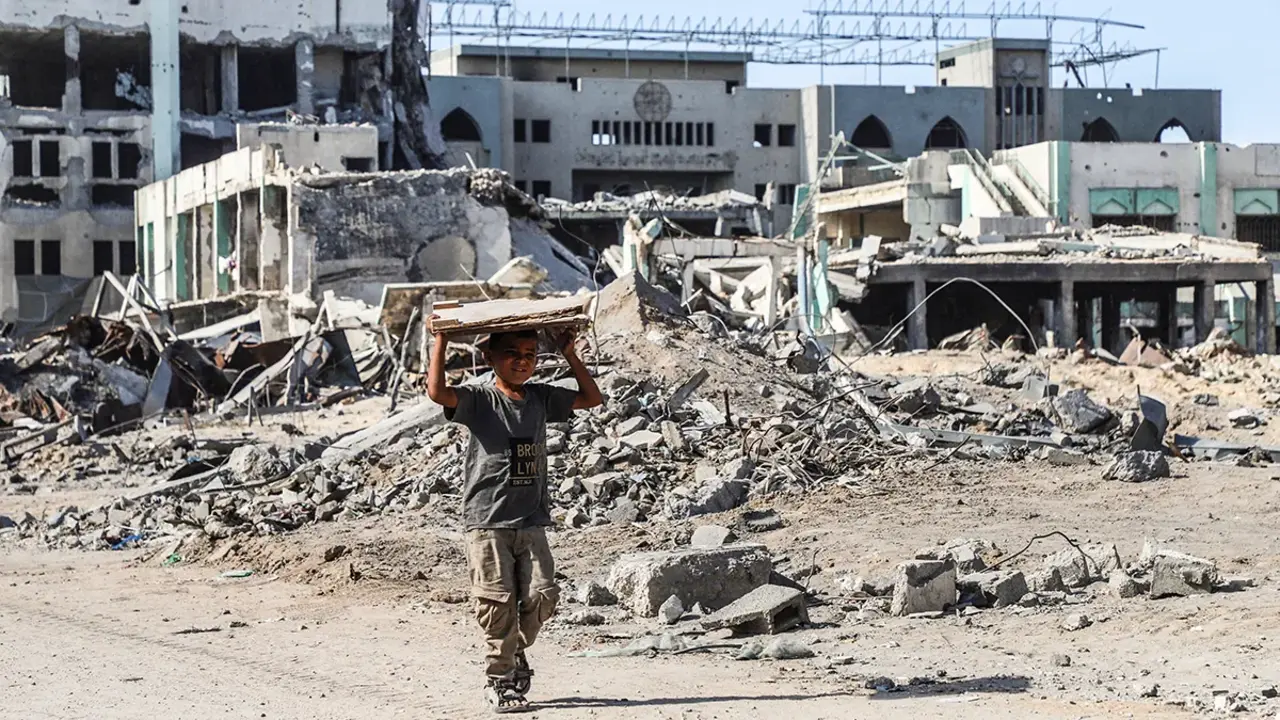 <p>Un ni&ntilde;o palestino camina con un trozo de madera en la mano, en medio de un alto el fuego entre Israel y Ham&aacute;s, en la ciudad de Gaza, el 16 de octubre de 2025 - REUTERS/ EBRAHIM HAJJAJ</p>
