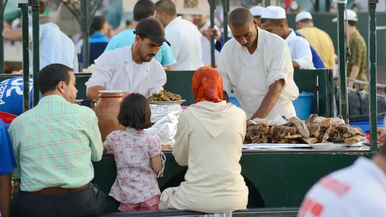 Familia marroqu&iacute; disfrutando de uno de los puestos de comida de la plaza de Yamaa el Fna, Marrakech&nbsp;- <a href="https://depositphotos.com/es/?/">Depositphotos</a>