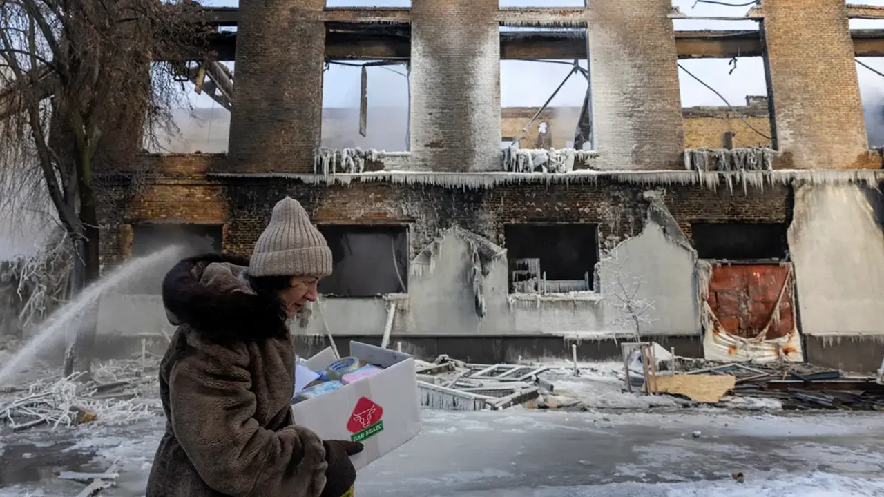 Una mujer pasa junto a un edificio que fue alcanzado por un dron ruso, en medio del ataque de Rusia a Ucrania, en Kiev, Ucrania, el 12 de enero de 2026 - REUTERS/ THOMAS PETER