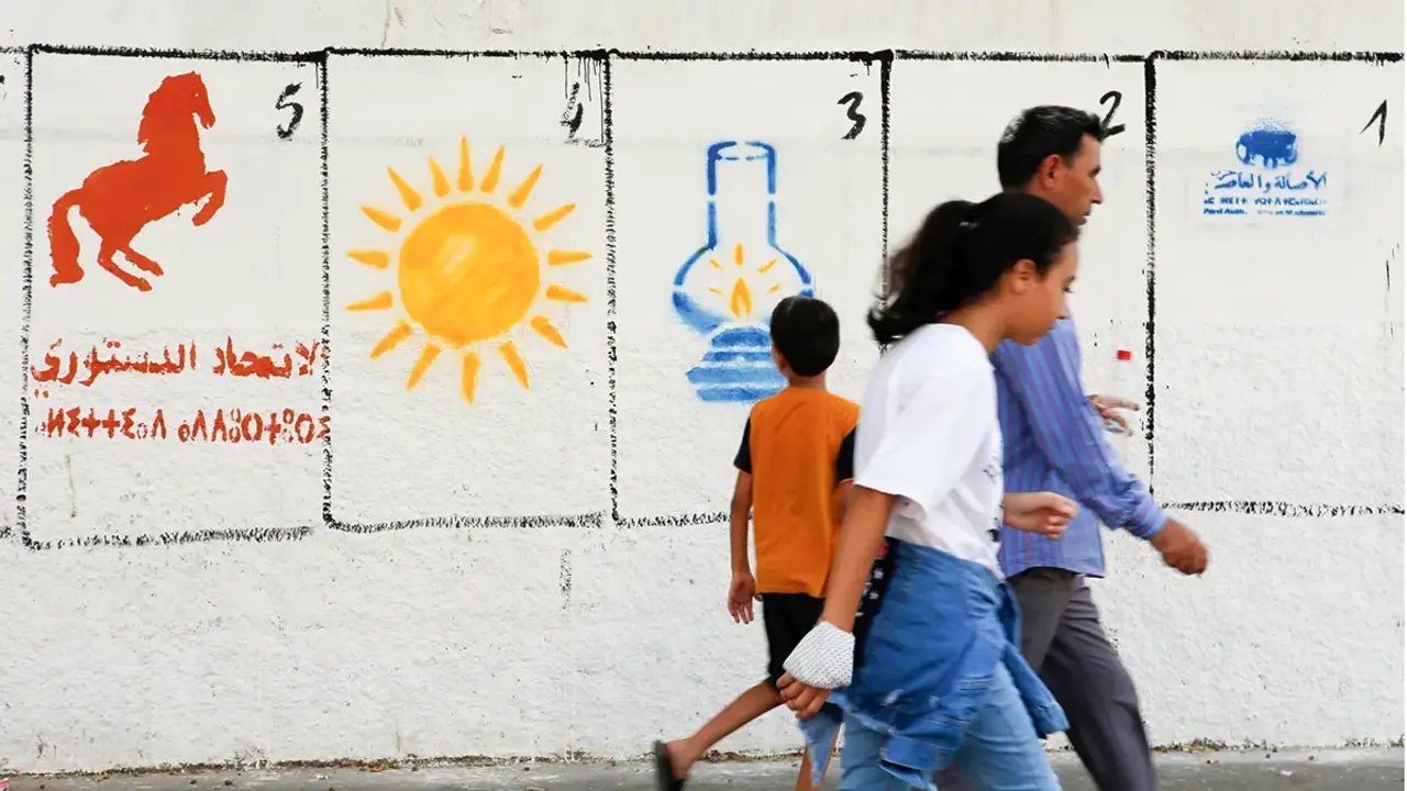 <p>Una familia marroqu&iacute; pasa junto a pinturas electorales que representan los logotipos de un partido pol&iacute;tico para las elecciones municipales en Casablanca, Marruecos - AP/ ABDELJALIL BOUNHAR</p>
