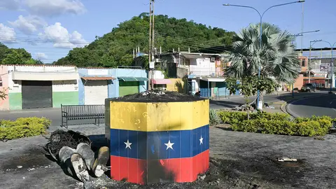 Los restos de una estatua del fallecido presidente venezolano Hugo Chávez destruidos y quemados durante una protesta contra el gobierno del presidente venezolano Nicolás Maduro se muestran en Mariara, estado de Carabobo, Venezuela, el 31 de julio de 2024 - AFP/YURI CORTEZ
