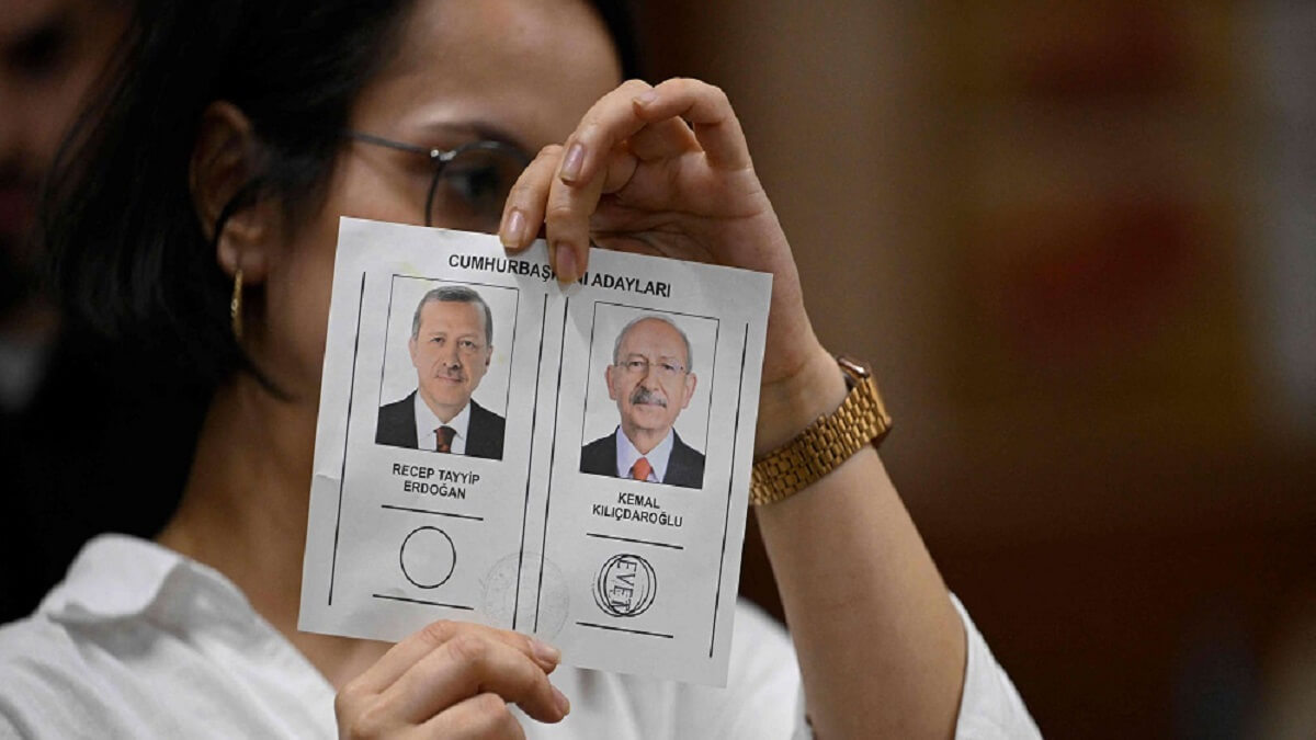 PHOTO/AFP/YASIN AKGUL – Una mujer sostiene una papeleta de voto