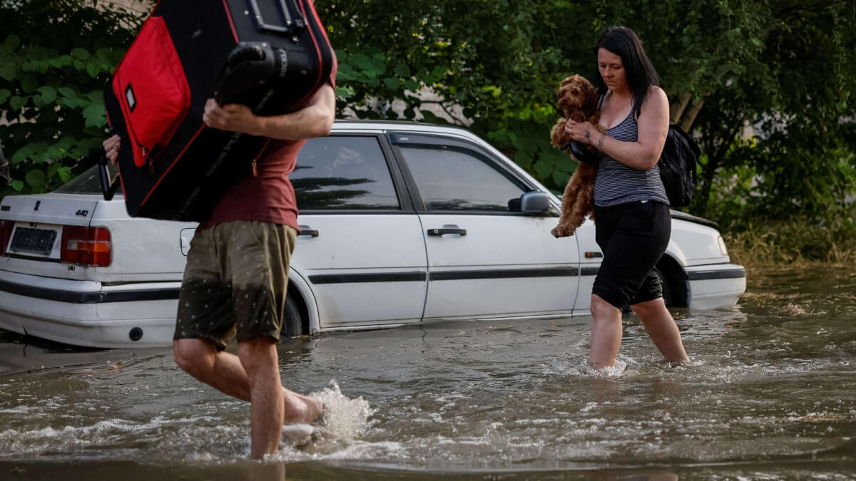 PHOTO /REUTERS - Los residentes locales llevan sus pertenencias personales en una calle inundada, después de la ruptura de la presa Nova Kakhovka, en medio del ataque de Rusia a Ucrania, en la región de Kherson, Ucrania, 6 de junio de 2023